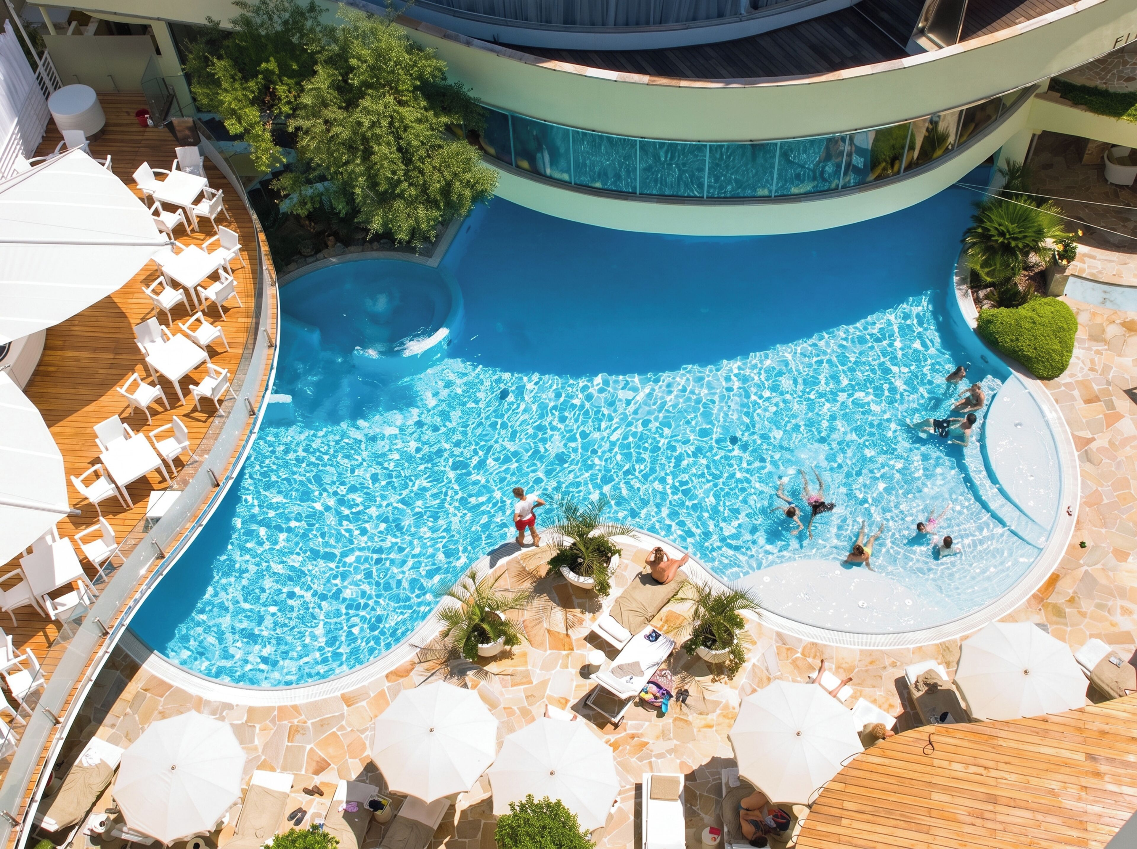 A rooftop pool with multiple levels, surrounded by lounge chairs and umbrellas.
