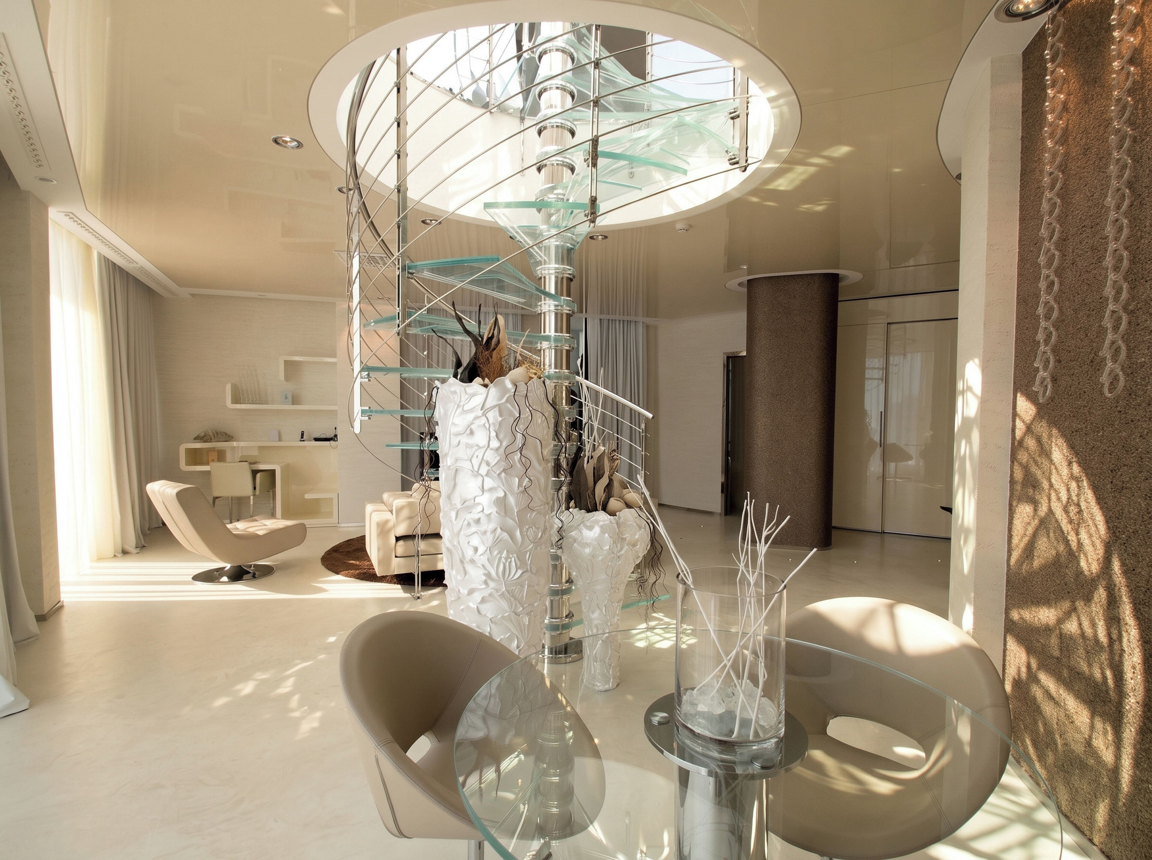 A modern interior with a spiral staircase, a glass table, and contemporary furniture.