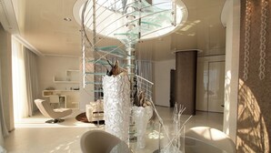 A modern interior with a spiral staircase, a glass table, and contemporary furniture.
