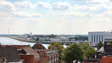 A riverside view with industrial buildings and a bridge.