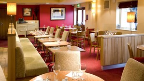 A restaurant with multiple tables, chairs, and a bar area. - Premier Inn Heathrow Airport - M4/J4 (Hayes)