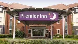 Entrada de un hotel con un cartel que dice 'Premier Inn' y un símbolo de luna creciente.