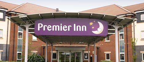 A hotel entrance with a marquee sign reading 'Premier Inn' and a crescent moon symbol.