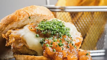 Un sandwich avec un pain croustillant, du fromage fondu et une garniture d’oignons caramélisés et d’oignons verts.