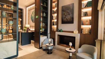 Una sala moderna con chimenea, estanterías y objetos decorativos.