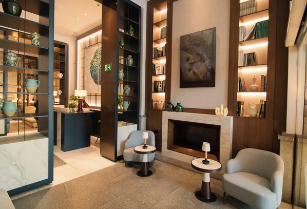 Una sala moderna con chimenea, estanterías y objetos decorativos.