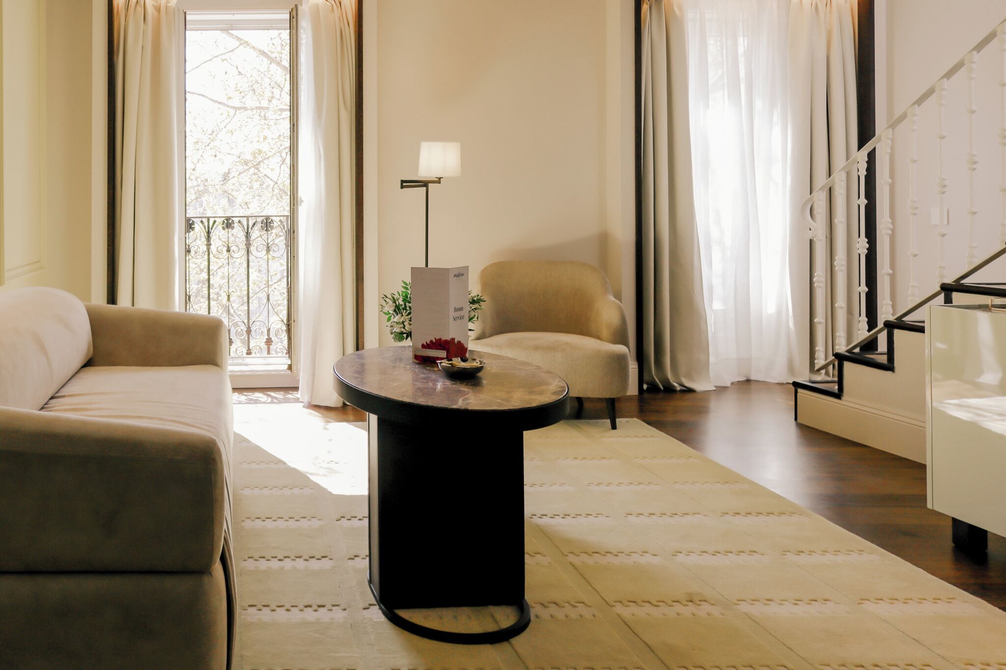 A living room with a sofa, a round coffee table, a lamp, and a chair.