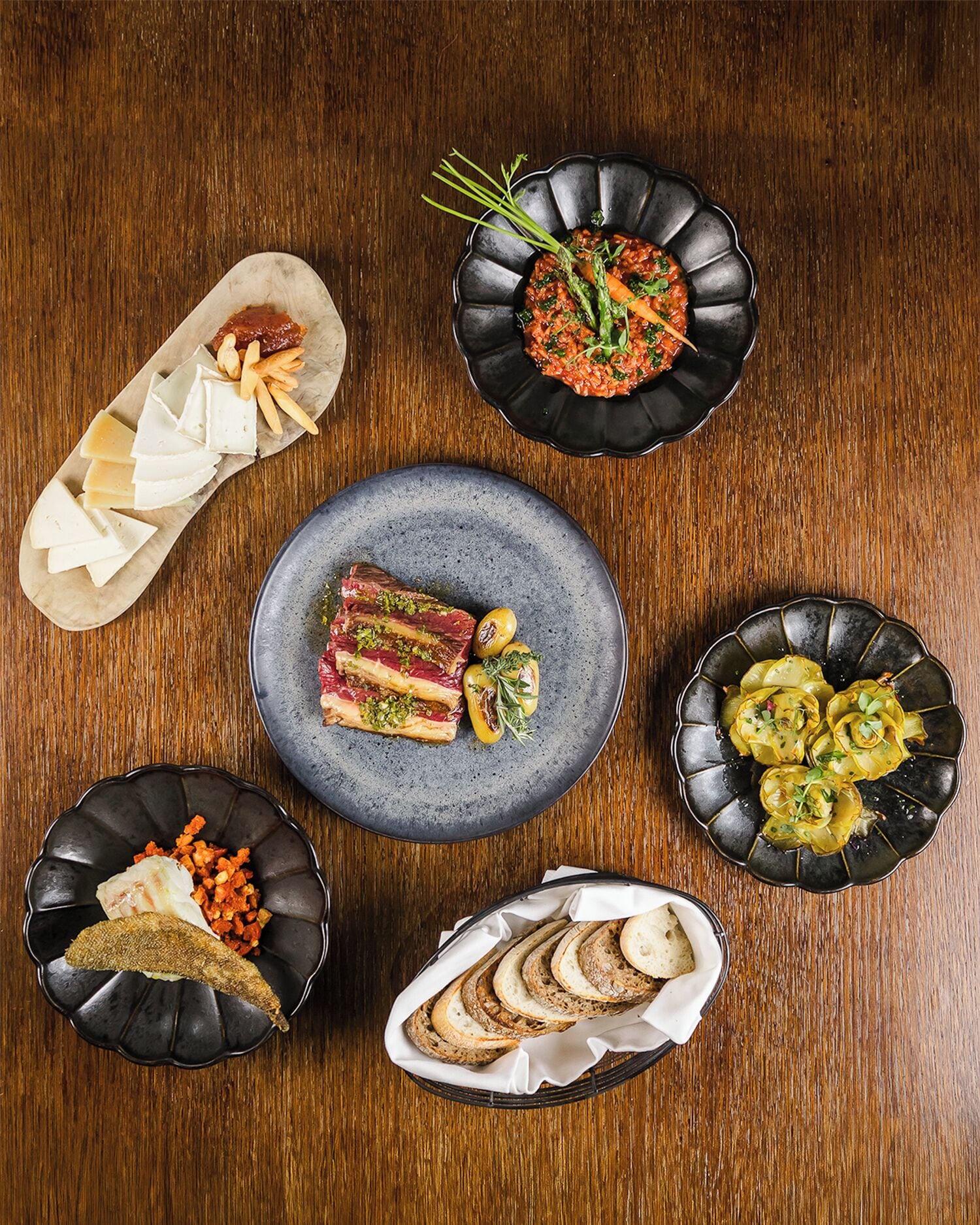 A variety of dishes arranged on a wooden table.