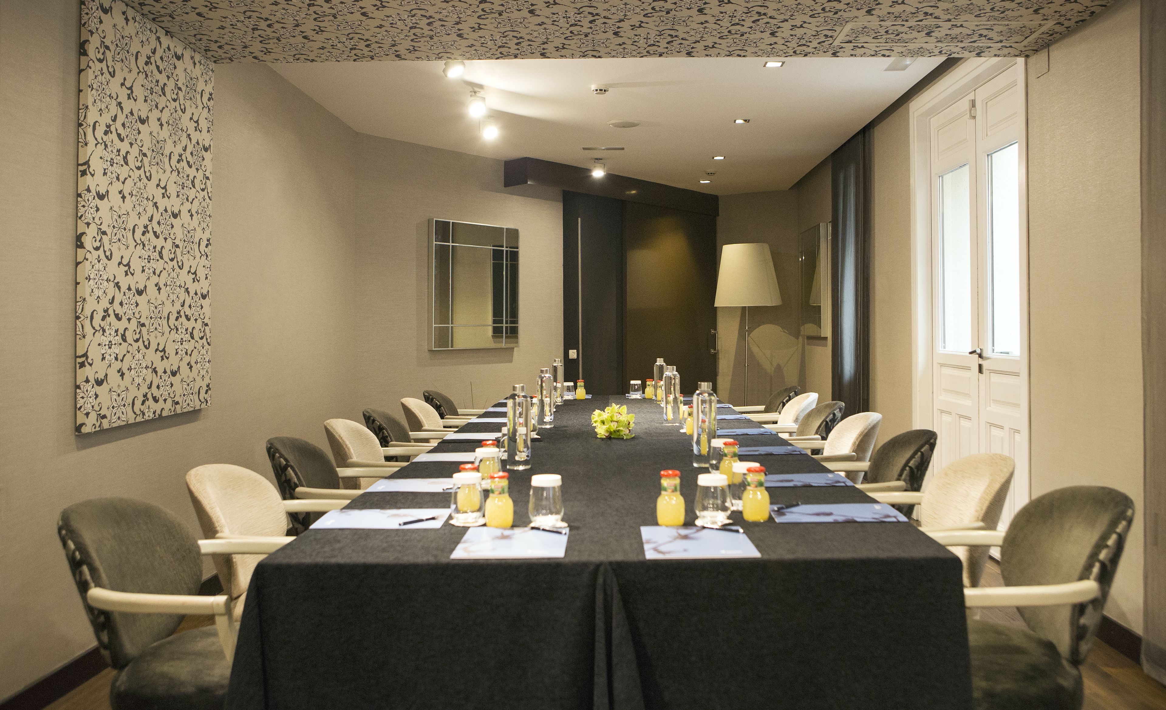 A conference room with a long table, chairs, and amenities like water bottles and notepads.