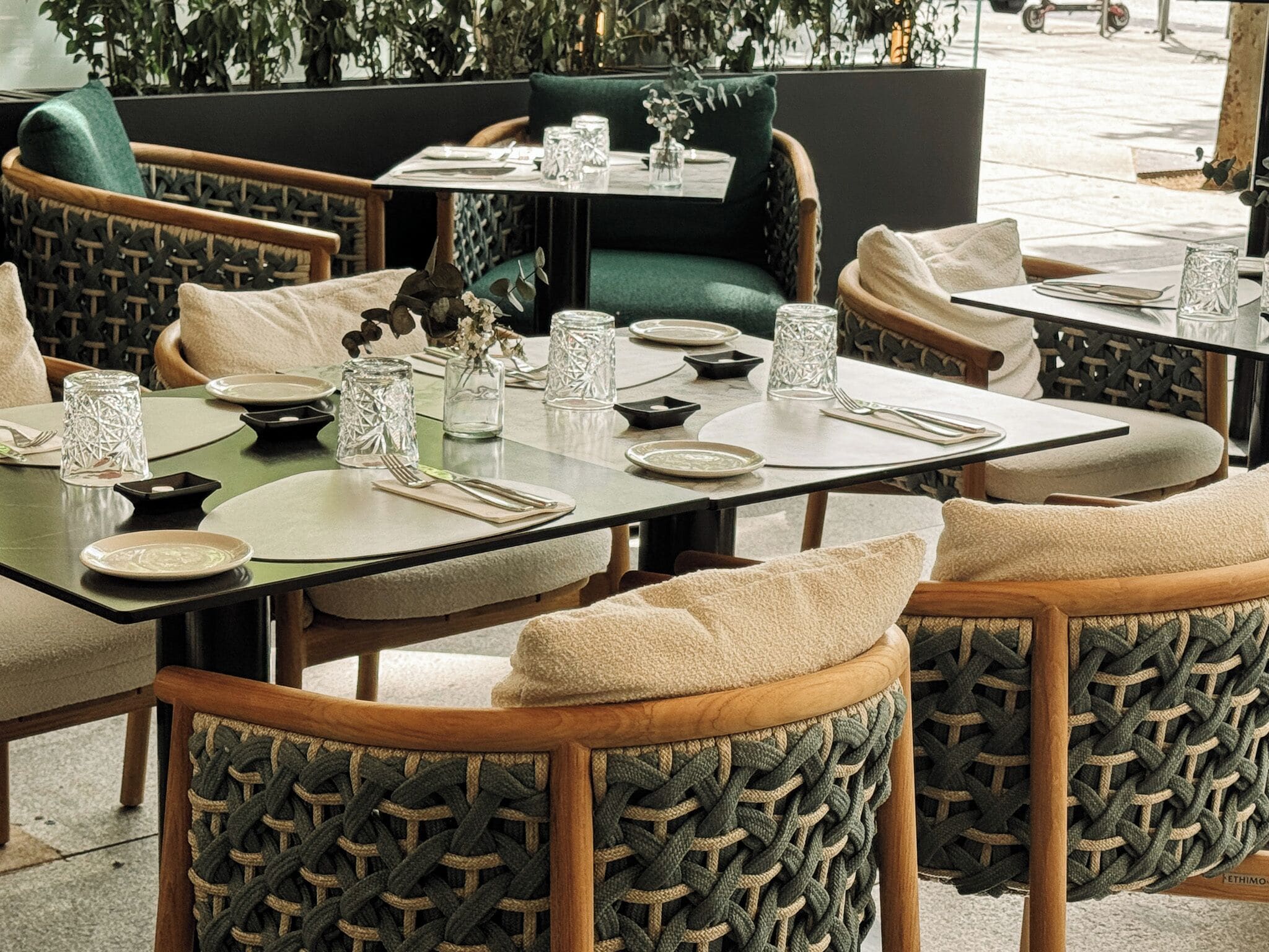 Ein Restaurant mit runden Tischen, gepolsterten Stühlen und Gläsern.