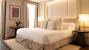 Habitación de hotel ordenada con una cama grande, mesitas de noche y una lámpara de pared.