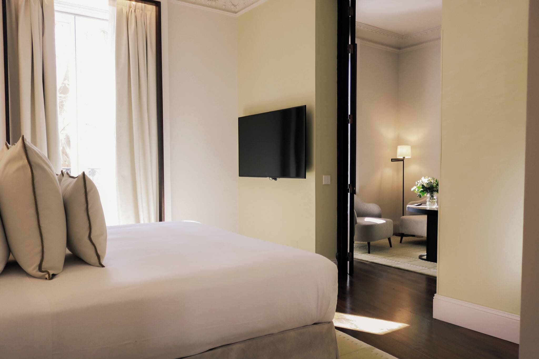 Une chambre d’hôtel équipée d’un lit, d’un téléviseur à écran plat, d’un bureau avec une lampe et d’une chaise.
