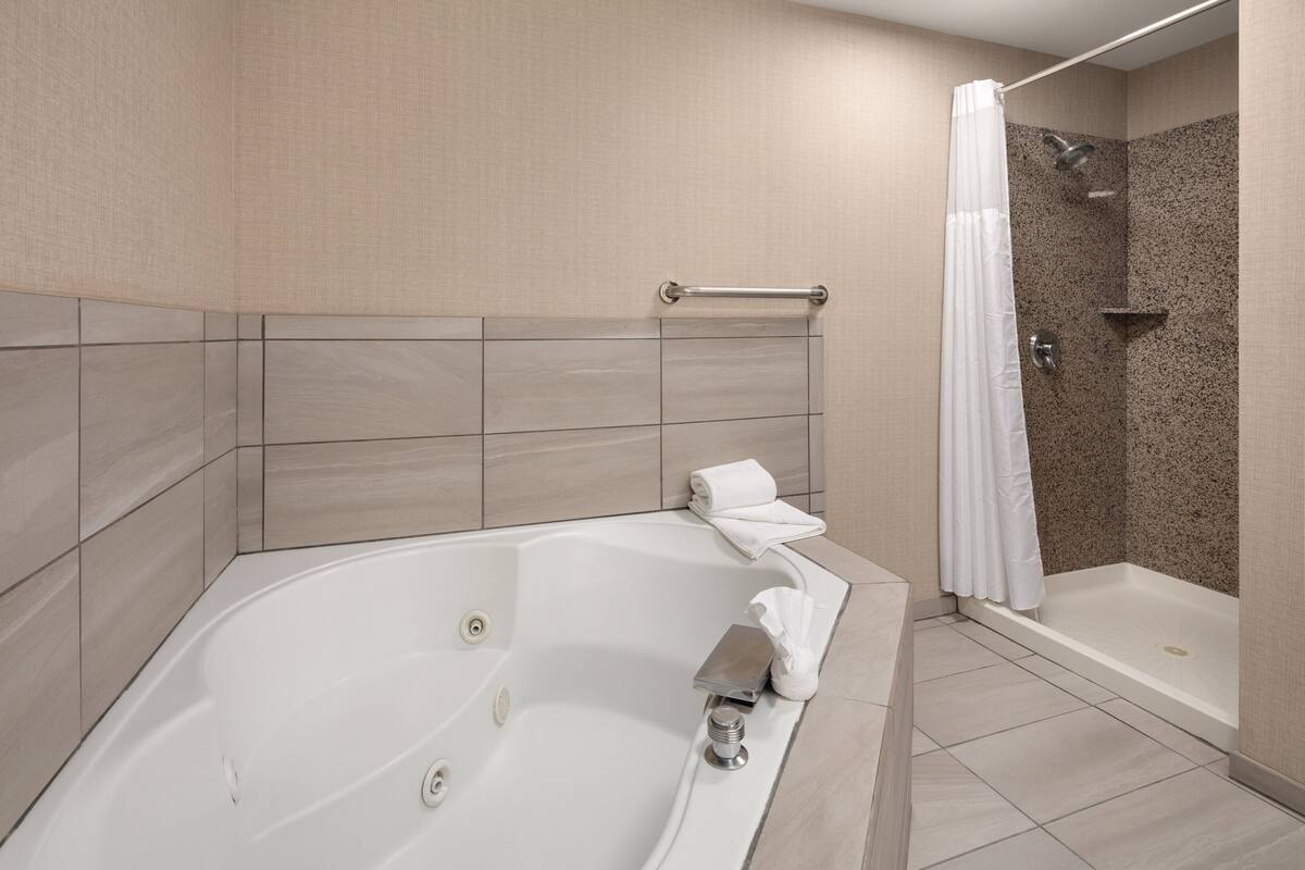 premium suite, 1 king bed, jetted tub | 1 bedroom, desk, laptop workspace, blackout curtains