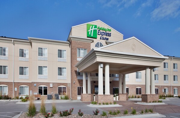 A Holiday Inn Express & Suites building with a covered entrance, brick facade, and multiple windows. - Holiday Inn Express & Suites Cherry by IHG (Omaha)