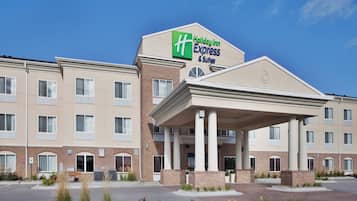 A Holiday Inn Express & Suites hotel with a covered entrance and multiple windows.