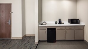 A compact kitchen with a microwave, coffee maker, and dishwasher.