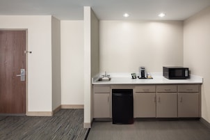 Una cocina compacta equipada con microondas, cafetera y lavavajillas.