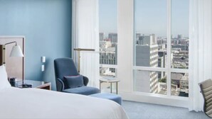 A hotel room with a large window offering a city view, a bed, a desk with a lamp, and a chair. - InterContinental San Francisco by IHG (San Francisco)