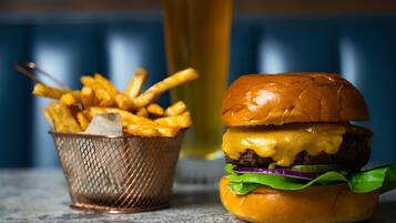 A burger and a basket of fries on a table.