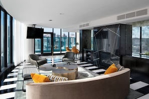 A modern living room with a sofa, chairs, a coffee table, a fireplace, and a large window with a city view. - InterContinental San Francisco by IHG (San Francisco)