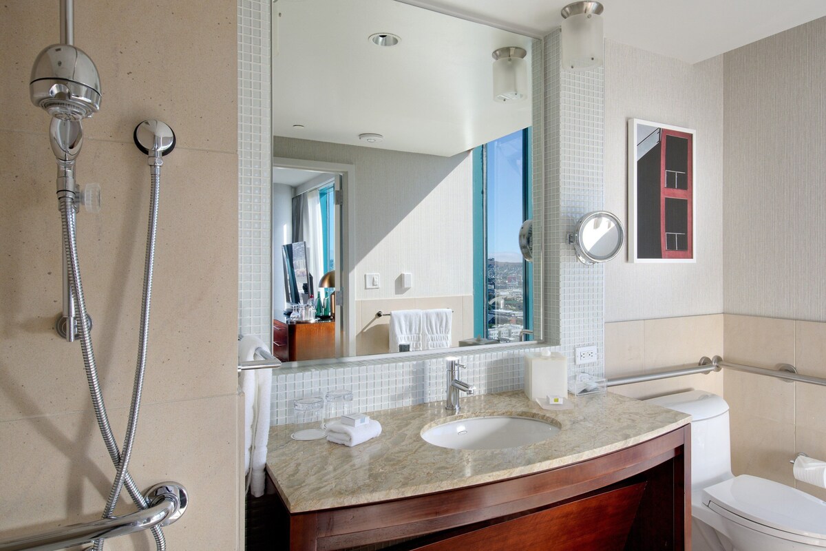 Une salle de bain avec un lavabo, un miroir et une douche.