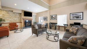 A spacious living area with sofas, a fireplace, and artwork on the walls.
