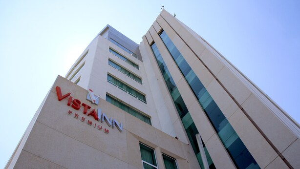 Un edificio alto con un llamativo letrero que dice 'Vista Inn Premium'.