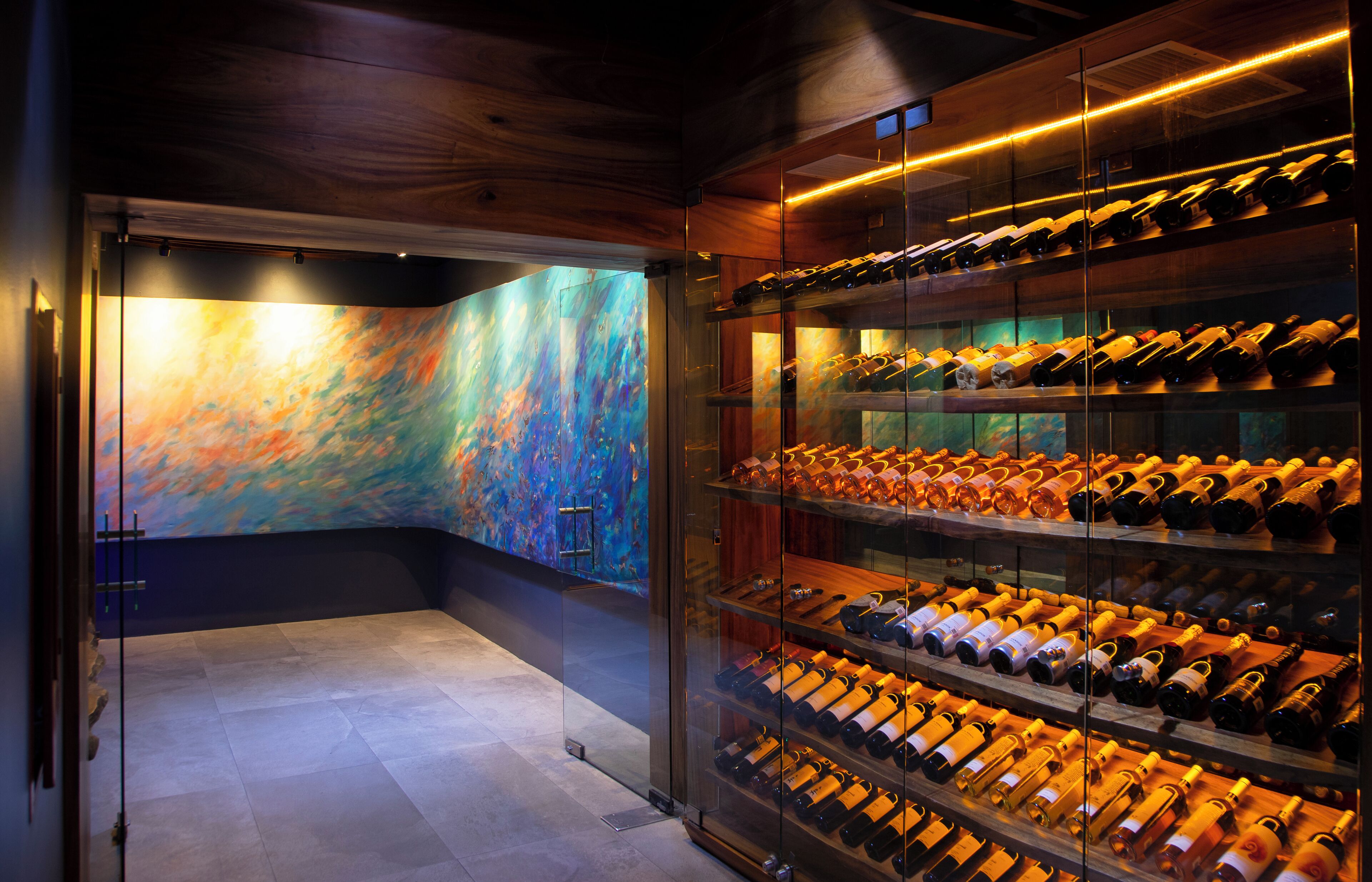 A wine cellar with glass doors and shelves of wine bottles.