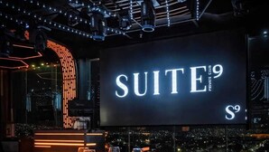 Un área de descanso moderna con un letrero iluminado que dice "SUITE 9".