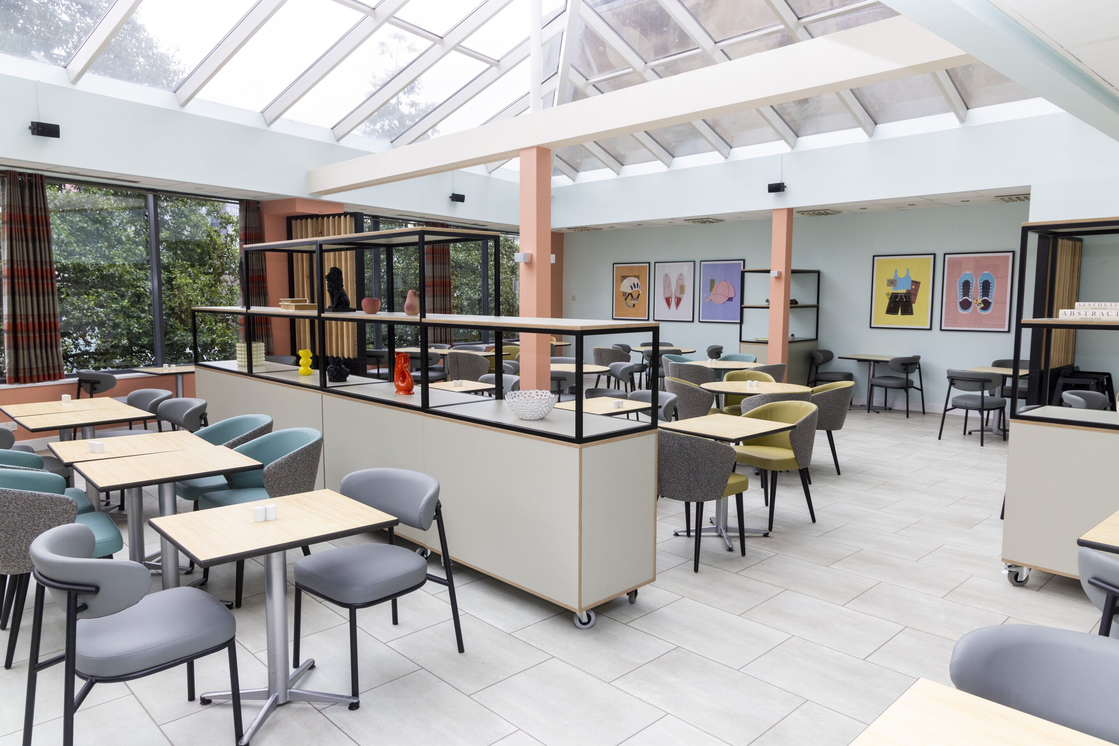 A modern classroom with tables, chairs, and a glass ceiling.