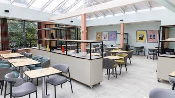A modern classroom with tables, chairs, and a glass ceiling.