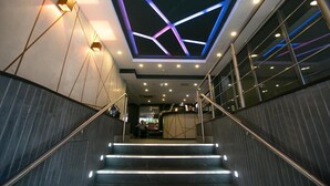 A modern staircase with a geometric ceiling design and illuminated handrails. - Garner Hotel Nottingham City Centre by IHG (Nottingham)