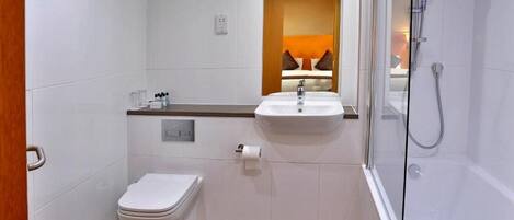 A modern bathroom with a toilet, sink, and shower.