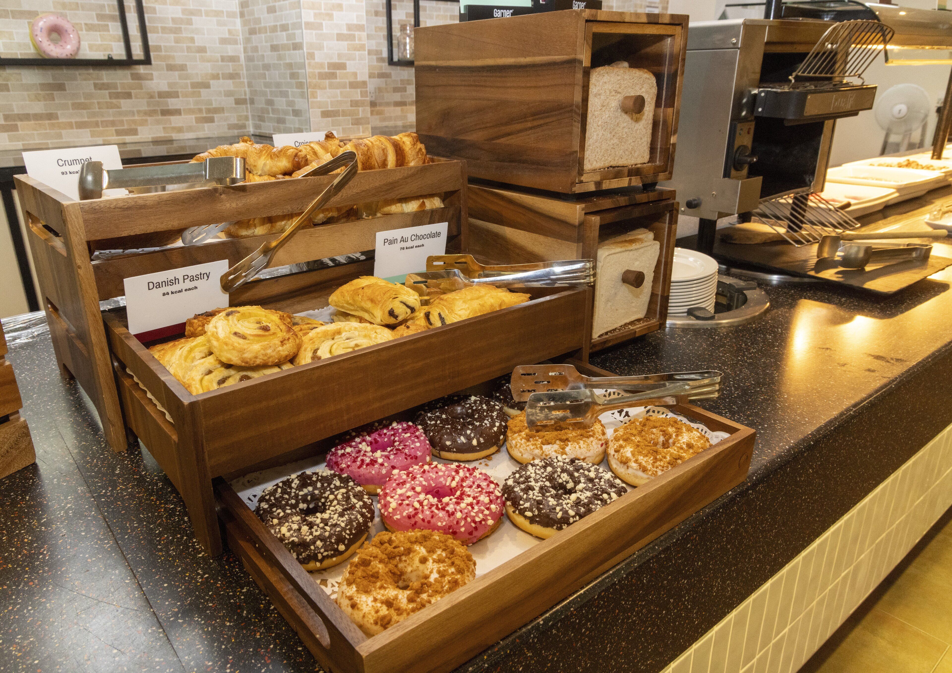 A bakery display with various pastries and donuts.