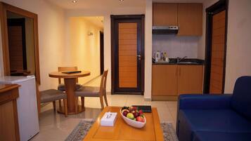 A compact living space with a dining area, kitchenette, and a blue sofa.