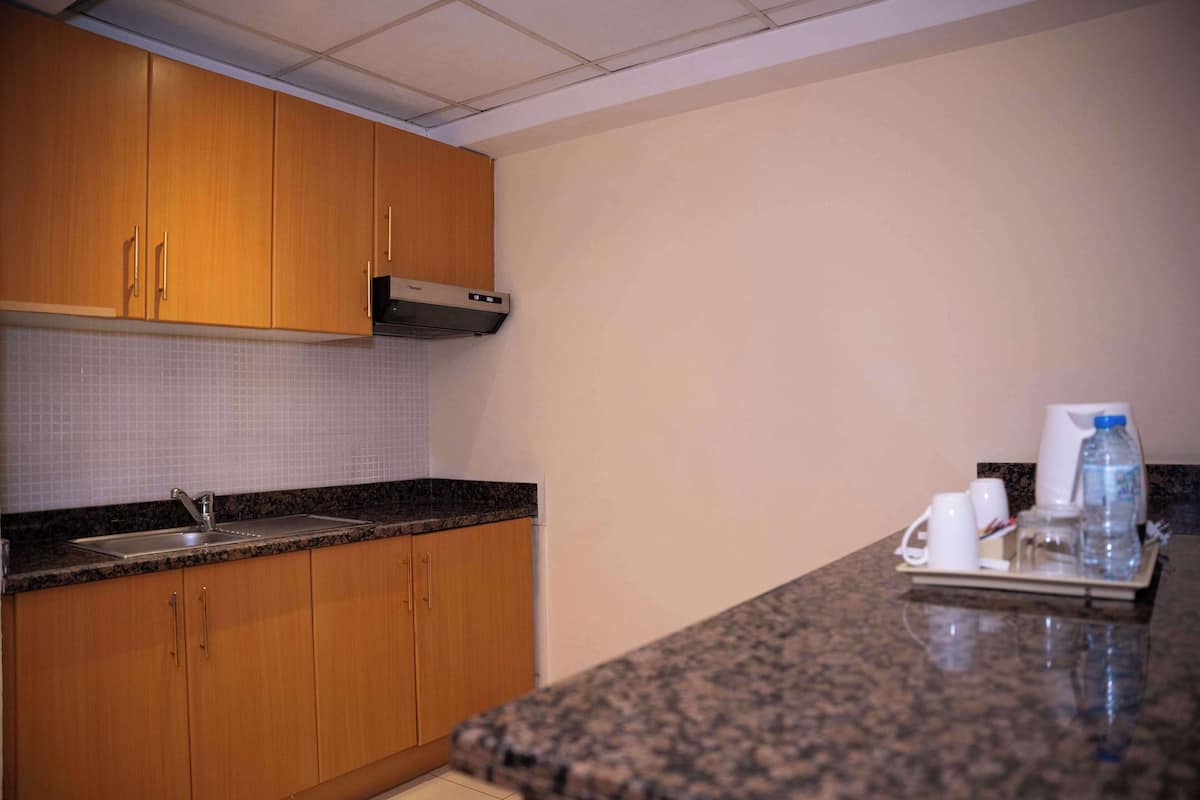 A kitchen with wooden cabinets, a stainless steel sink, and a granite countertop.