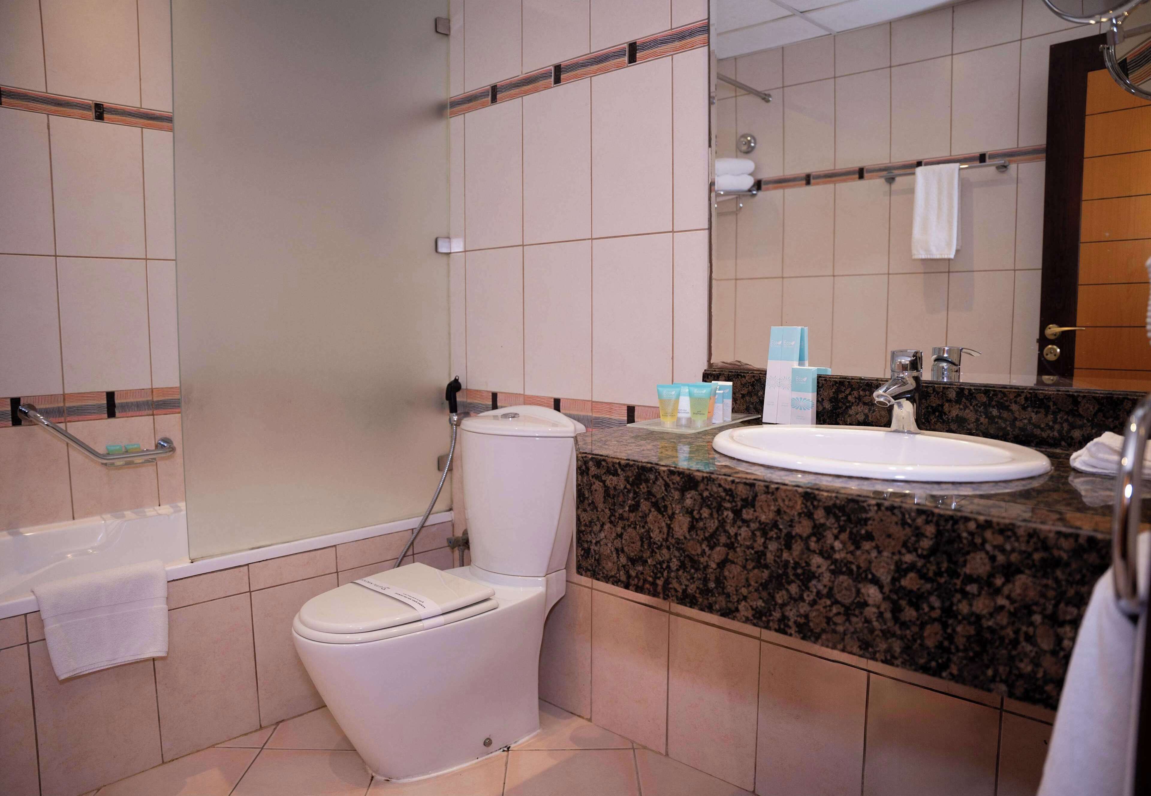 Une salle de bain avec des toilettes, un lavabo et une baignoire.
