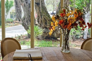 A wooden table with an open book and a clear vase of flowers. - Parga Beach Resort (Parga)