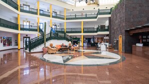 Un vestíbulo amplio con una zona de estar central, varios pisos y una escalera.
