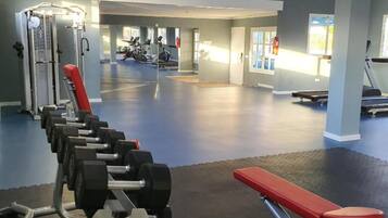 Ein Fitnessstudio mit Krafttrainingsgeräten, Laufbändern und Trainingsmaschinen.