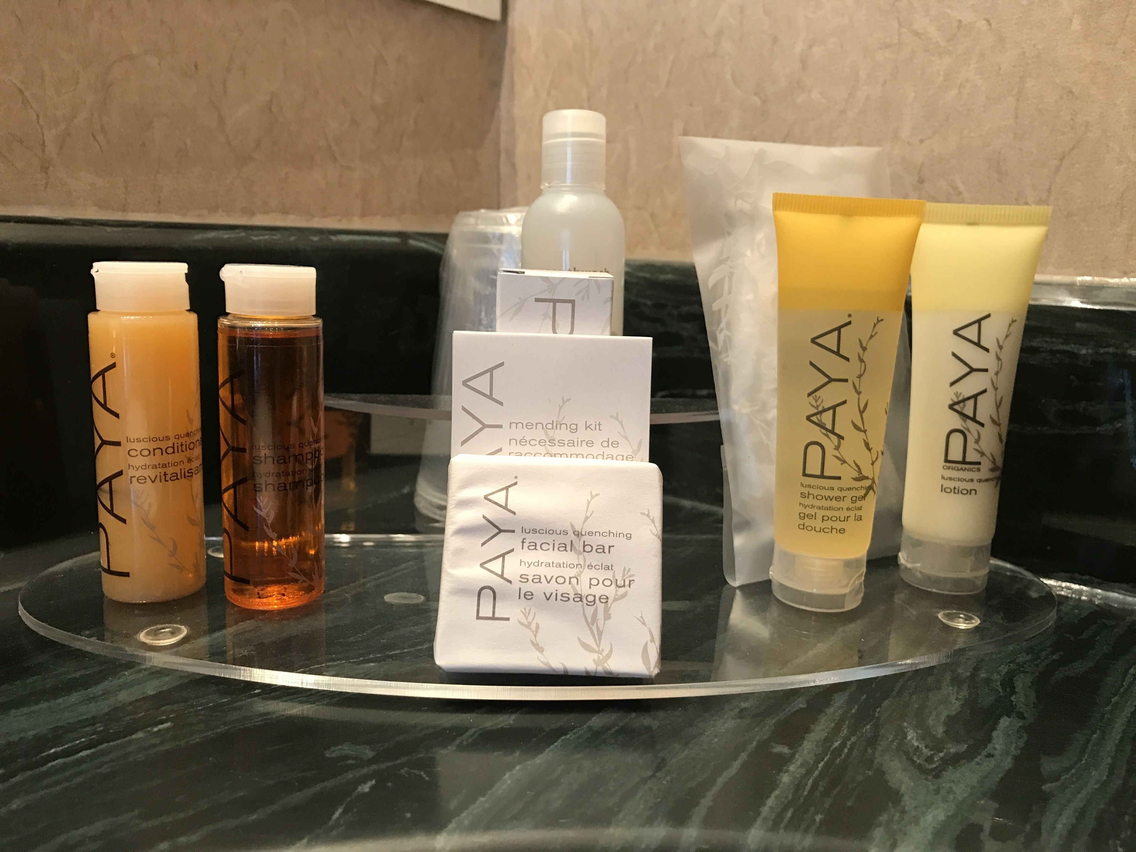 Un meuble de salle de bain sur lequel sont disposés divers produits de soins de la peau de la marque PAYA, notamment des lotions et un savon pour le visage.