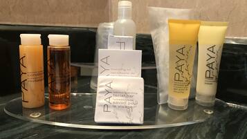 A bathroom counter with various PAYA skincare products, including lotions and a facial bar.