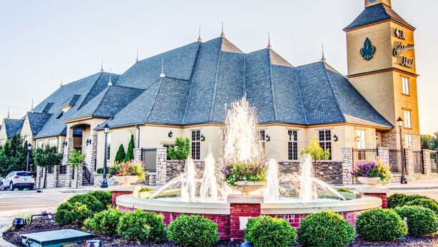 Un hôtel doté d’une tour imposante, d’une fontaine dans la cour et d’un jardin bien entretenu.
