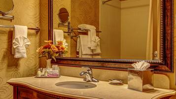 A bathroom with a large mirror, vanity, and towel rack.
