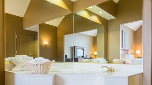 Une salle de bain moderne avec un grand miroir, un meuble-lavabo blanc et une baignoire.
