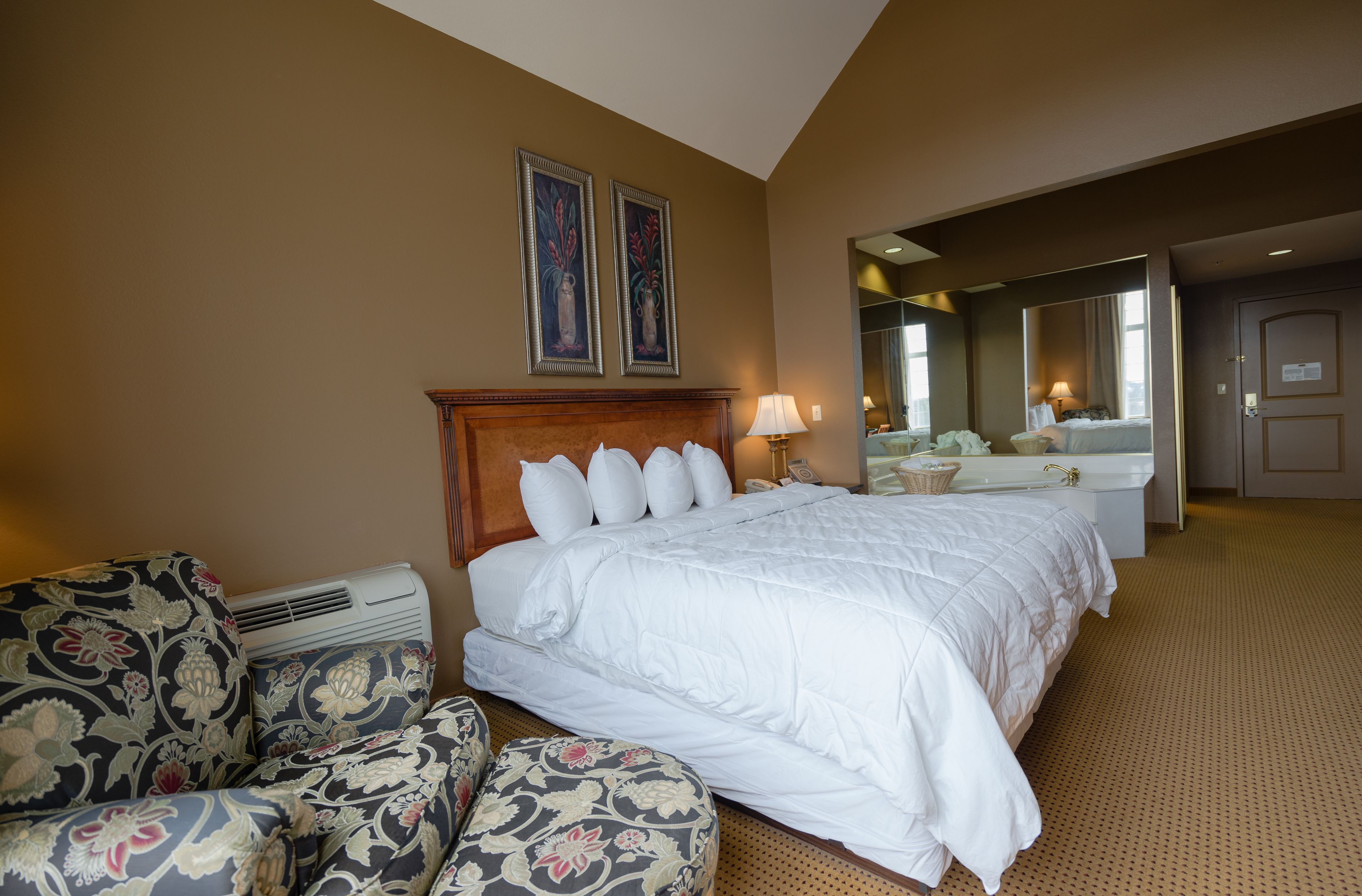 Una habitación de hotel con una cama grande, un sofá, un escritorio y un baño.