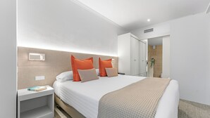 Et moderne hotelværelse med en stor seng, to sengeborde, et natbord og et garderobeskab.