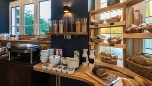 A breakfast buffet with various food items and containers. - guestified. BARBAROSSA Hotel (Ratingen)