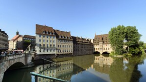 A historic European town with a river, stone bridges, and traditional buildings. - Hotel Metropol Nürnberg (Nuremberg)