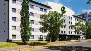A modern B&B hotel with a white facade, multiple windows, and a green logo. - B&B Hotel Frankfurt-Niederrad (Frankfurt)